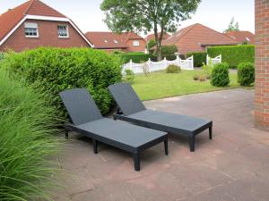 two chairs sitting on a patio in a yard at Holiday Home Christa - HOK110 by Interhome in Hooksiel