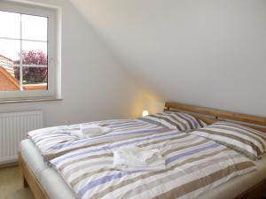 a bedroom with a bed with two towels on it at Holiday Home Christa - HOK110 by Interhome in Hooksiel