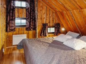 ein Schlafzimmer mit einem Bett in einer Holzhütte in der Unterkunft Holiday Home Örtsylä b by Interhome in Salla