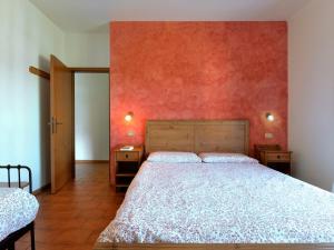 カルドナッツォにあるApartment Anna-2 by Interhomeの赤い壁のベッドルーム1室(ベッド1台付)