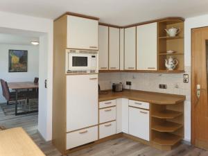 a kitchen with white cabinets and a microwave at Apartment Nürburgblick by Interhome in Quiddelbach