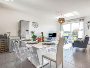 Port-HaliguenにあるApartment Le Domaine de Fort Neuf by Interhomeのテーブルと椅子のあるキッチンとダイニングルーム