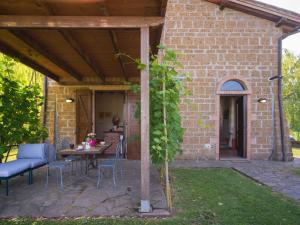 a patio with a table and chairs and a brick building at Apartment Casa Ricardo n- 4 by Interhome in Montefiascone