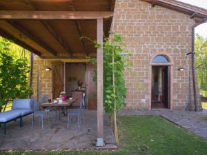 un patio con tavolo e sedie e un edificio in mattoni di Apartment Casa Ricardo n- 4 by Interhome a Montefiascone