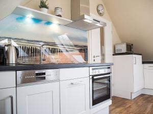 een keuken met witte kasten en een aanrechtblad bij Apartment Witthuus-Wangerooge by Interhome in Norddeich