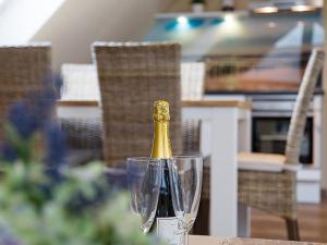 een fles champagne zittend op een tafel met twee glazen bij Apartment Witthuus-Wangerooge by Interhome in Norddeich