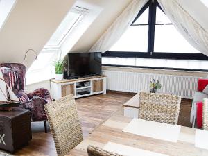 een woonkamer met een tv en een aantal stoelen bij Apartment Witthuus-Wangerooge by Interhome in Norddeich