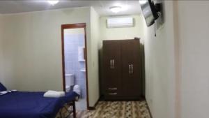 a room with a bed and a door and a television at Hospedaje J.R in Chitré
