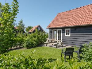 a yard with a chair and a house at Holiday Home Zeeuwse Cottage Wemeldinge-5 by Interhome in Wemeldinge