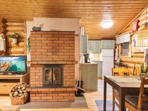 a living room with a brick fireplace in a house at Holiday Home Kuusipirtti by Interhome in Ylläsjärvi