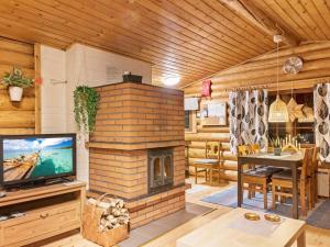 ユッラスヤルヴィにあるHoliday Home Kuusipirtti by Interhomeのリビングルーム(レンガ造りの暖炉、テレビ付)