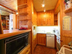 a kitchen with wooden cabinets and a sink and a dishwasher at Apartment Le Curling A - Val Claret-17 by Interhome in Tignes