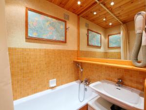 ein Badezimmer mit einer weißen Badewanne und einem Waschbecken in der Unterkunft Apartment Le Curling A-17 by Interhome in Tignes