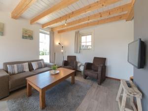 een woonkamer met een bank en een tafel bij Holiday Home Zeeuwse Cottage Wemeldinge-3 by Interhome in Wemeldinge
