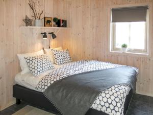 ein Schlafzimmer mit einem Bett in einem Zimmer mit Holzwänden in der Unterkunft Chalet Eikebu - SOW137 by Interhome in Fossdal