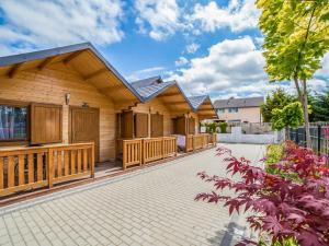 a wooden house with a walkway in front of it at Holiday Home Onyx-1 by Interhome in Mielno