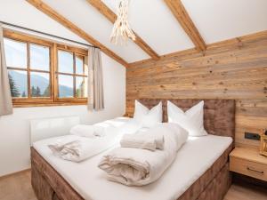 two beds in a room with wooden walls and windows at Holiday Home Waldkauz-1 by Interhome in Pfarrwerfen