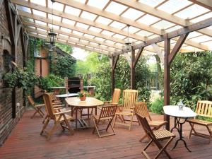 a patio with tables and chairs under a pergola at Holiday Home Gościniec Pod Dwoma Sercami by Interhome in Tuplice