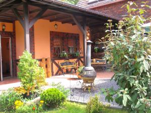 a patio with an outdoor fireplace on a house at Holiday Home Gościniec Pod Dwoma Sercami by Interhome in Tuplice