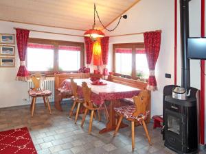 a dining room with a table and chairs and a stove at Apartment Cà Mia by Interhome in Dosso del Liro