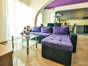 Apartment Škroćo by Interhome في ماسلينتسا: غرفة معيشة مع أريكة أرجوانية وطاولة زجاجية