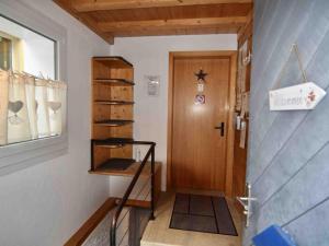 einen Flur mit einer Tür und einem Regal neben einer Tür in der Unterkunft Apartment Bühl 13 by Interhome in Engelberg