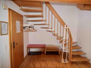eine Holztreppe mit einer roten Bank in einem Zimmer in der Unterkunft Apartment Bühl 13 by Interhome in Engelberg