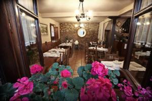 a restaurant with tables and pink flowers in the foreground at Posada La Solana in Santillana del Mar