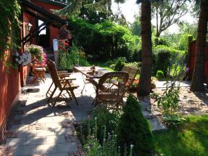 a patio with chairs and tables in a garden at Apartment Rekowo-1 by Interhome in Kamień Pomorski