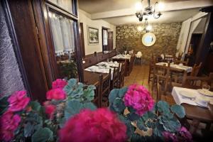 un restaurante con mesas y flores rosas en primer plano en Posada La Solana, en Santillana del Mar