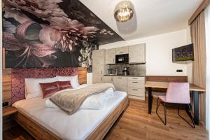 a bedroom with a large bed and a desk at Alpenperle Apartments in Ladis
