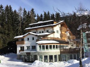 ein Gebäude im Schnee mit schneebedeckten Bäumen in der Unterkunft Glüxplatzl GmbH Appartements am Wald in Sankt Martin am Tennengebirge