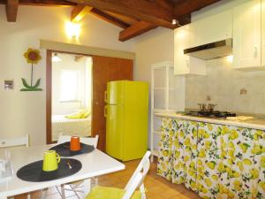 a kitchen with a white table and a yellow refrigerator at Holiday Home Chalet del Lago by Interhome in Bolsena