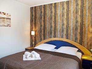 - une chambre avec un lit et un mur en bois dans l'établissement Apartment Witthuus-Baltrum by Interhome, à Norddeich