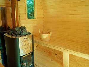 a corner of a sauna with a bucket of rocks at Holiday Home Villa Amber Gąski-3 by Interhome in Gąski