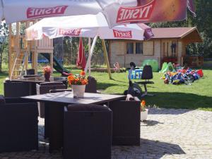 a picnic table with umbrellas and a playground at Holiday Home Villa Amber Gąski-3 by Interhome in Gąski