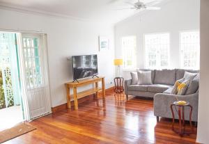 a living room with a couch and a tv at Hummingbird in Saint James