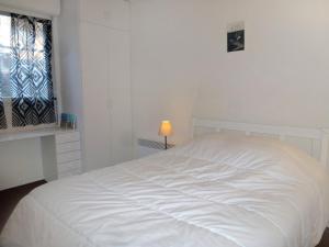1 cama blanca en un dormitorio blanco con ventana en Apartment Les Marinas-7 by Interhome en Deauville