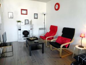 a living room with two red chairs and a table at Apartment Les Marinas-7 by Interhome in Deauville