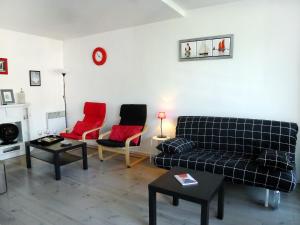 Apartment Les Marinas-7 by Interhome في دوفيل: غرفة معيشة مع أريكة وكرسيين