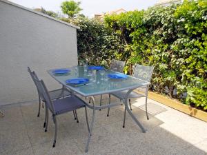 une table et des chaises en verre sur la terrasse dans l'établissement Holiday Home Les Jardins de l'Océan-38 by Interhome, à Pontaillac