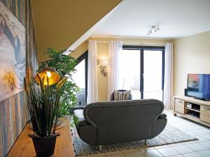 ein Wohnzimmer mit einem Sofa und einem TV in der Unterkunft Apartment Witthuus-Langeoog by Interhome in Norddeich