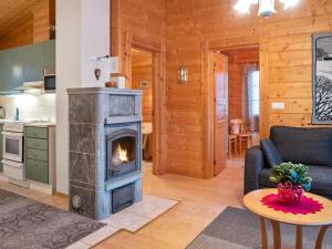 a living room with a fireplace in a log cabin at Holiday Home Kurre by Interhome in Lahdenperä