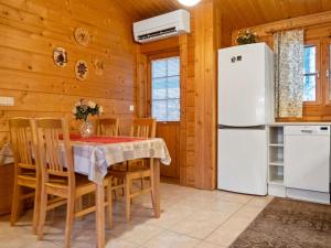 a kitchen with a table and a refrigerator at Holiday Home Kurre by Interhome in Lahdenperä