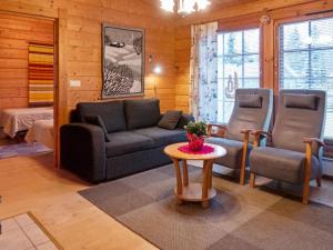 a living room with a couch and two chairs and a table at Holiday Home Kurre by Interhome in Lahdenperä
