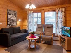a living room with a couch and a tv at Holiday Home Kurre by Interhome in Lahdenperä