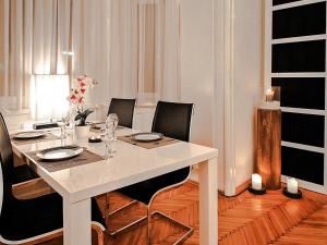 ウィーンにあるApartment Romantic Living by Interhomeのダイニングルームテーブル(黒い椅子、白いテーブル付)