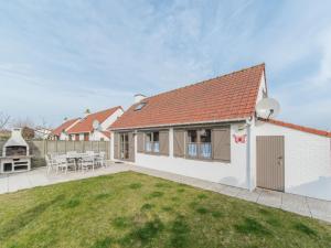 a home with a patio and a yard at Holiday Home Noordzeepark Zeewind 2-1 by Interhome in Mispelburg