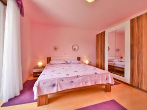 1 dormitorio con 1 cama grande y espejo en Apartment Fani-1 by Interhome en Rab