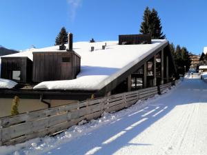 un edificio con techo cubierto de nieve en la nieve en Apartment Im Gruebi Apt- 10 by Interhome, en Wengen